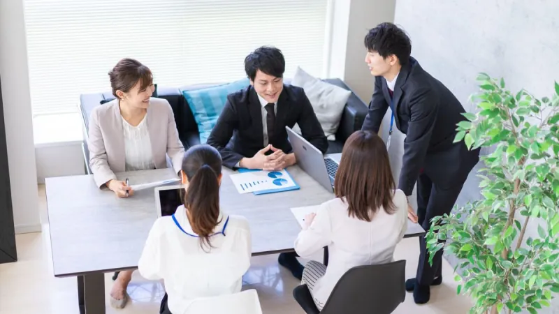 ホワイトボードを囲んで打ち合わせをするチーム